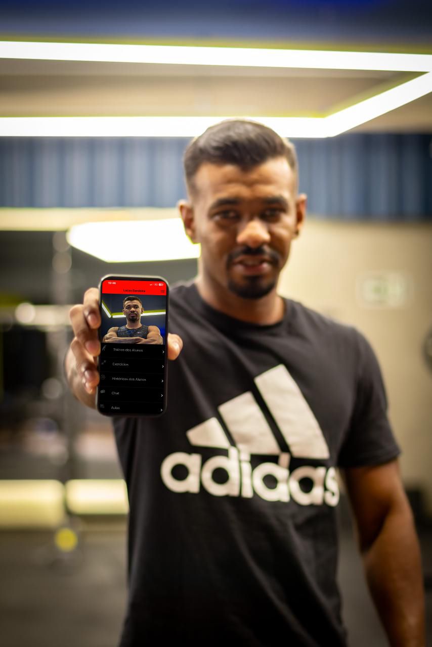 Lucas mostrando um aplicativo de treino no celular